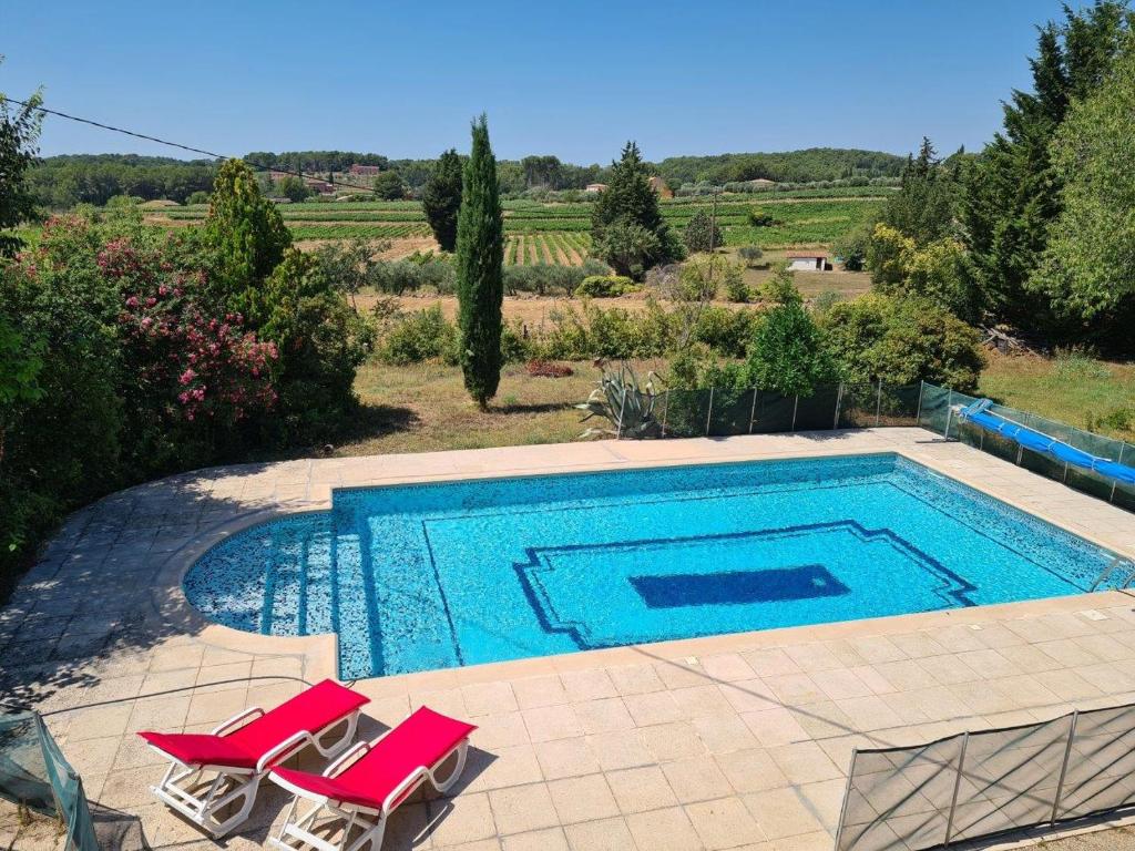 une piscine avec deux chaises longues et une piscine dans l'établissement Villa du clos d'Ières, à Draguignan