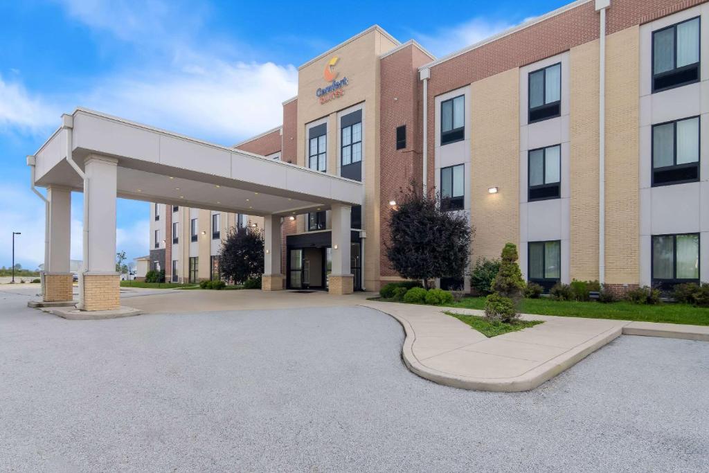 a large building with a parking lot in front of it at Comfort Suites Rensselaer near Fair Oaks in Rensselaer