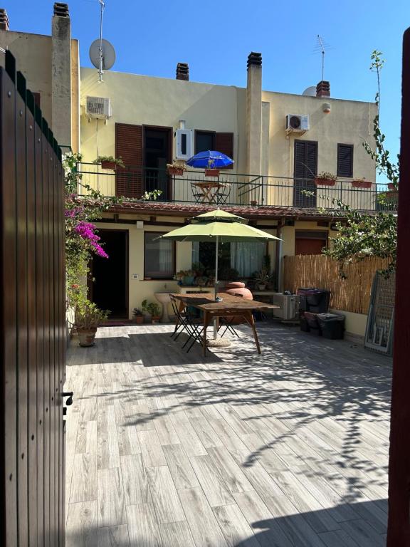a patio with a table and an umbrella at Casa Vacanze Eloise in Quartu SantʼElena