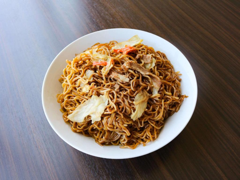a plate of noodles with meat and vegetables on a table at Comfort Hotel Central International Airport in Tokoname