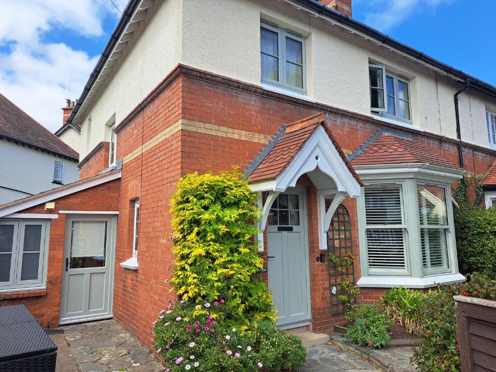 a red brick house with a white door at Dumble Cottage in Minehead