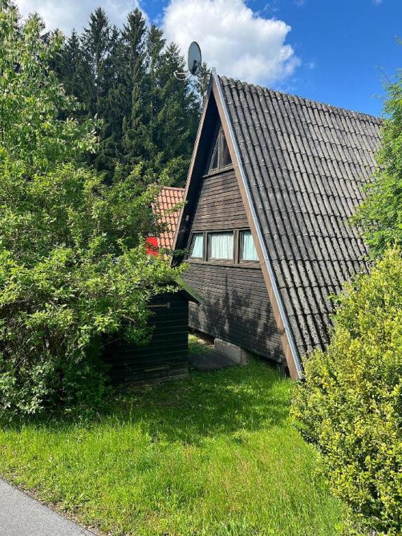 a house with a gambrel roof on top of a yard at Ferienhaus Meister Eder in Waldkirchen