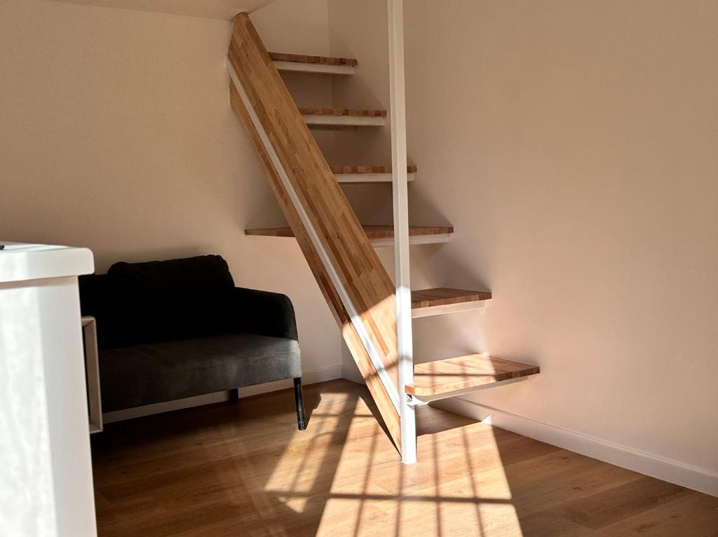 - un escalier dans une chambre avec un canapé et une chaise dans l'établissement Studio Metro Paris La-defense, à Asnières-sur-Seine