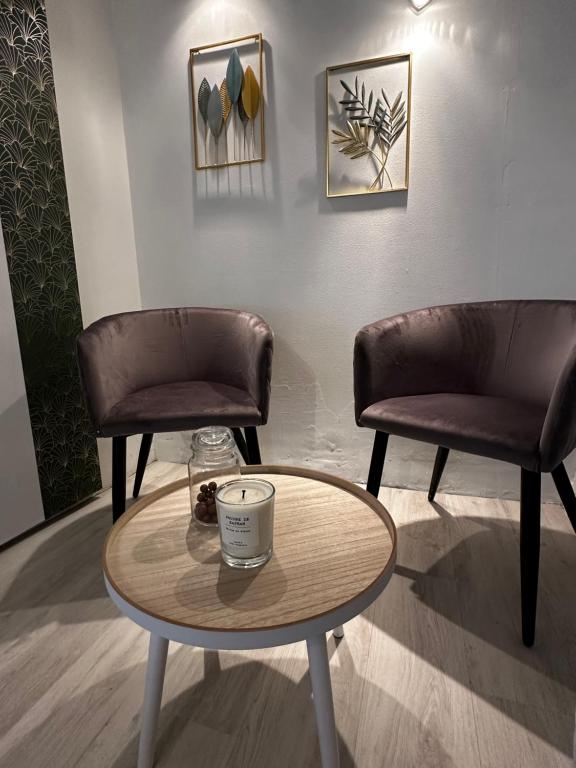 - deux chaises et une table basse dans une salle d'attente dans l'établissement Le repère studio, à Poitiers