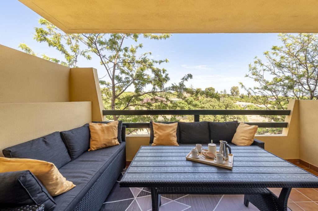 een patio met een blauwe bank en een tafel bij Apartamento Las Joyas in Estepona