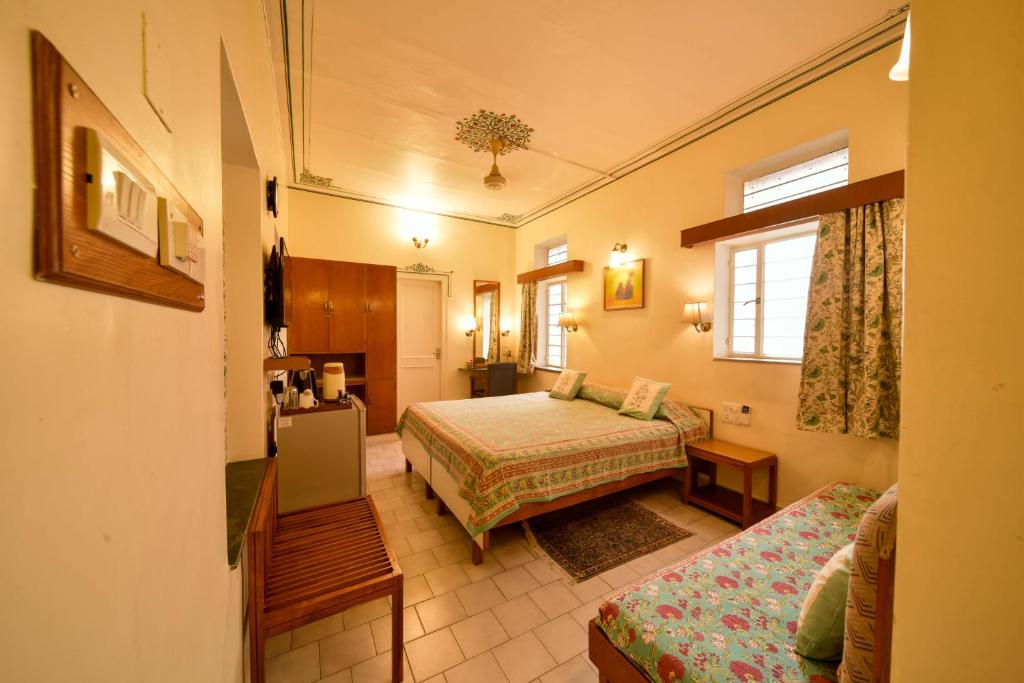 una camera d'albergo con due letti e un divano di Hotel Arya Niwas a Jaipur