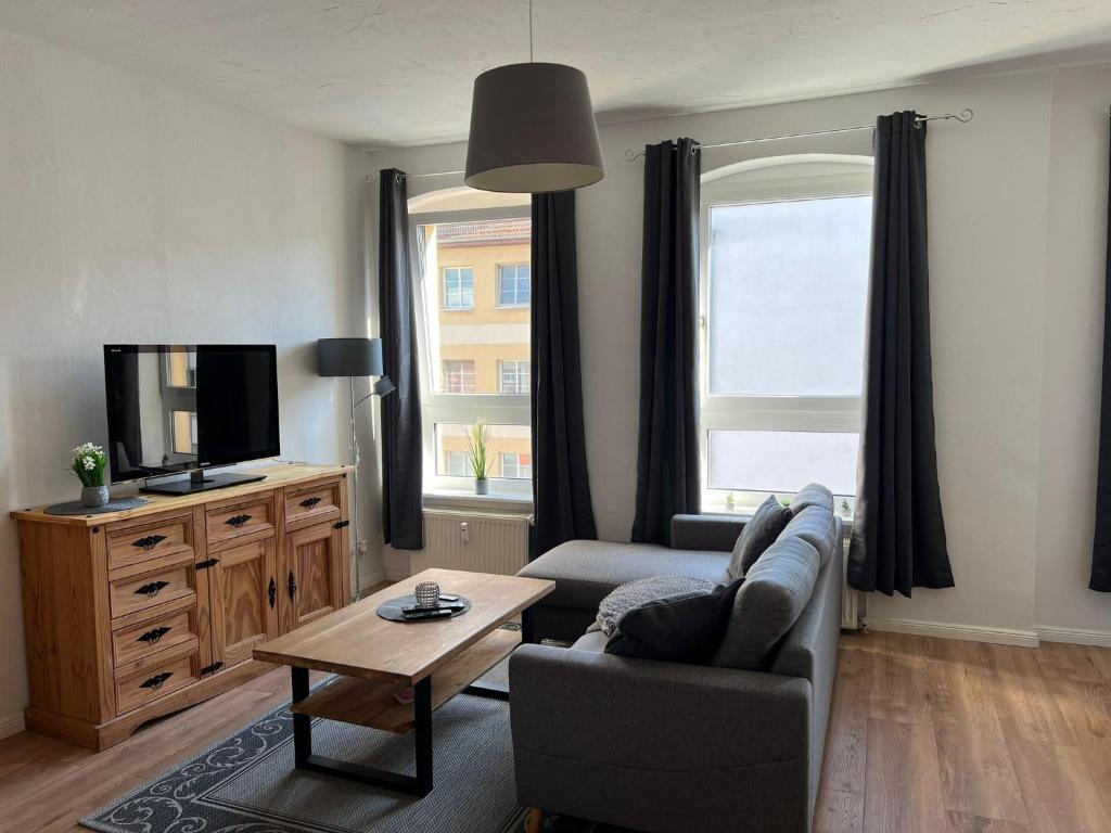 a living room with a couch and a tv at Altbauapartment in Wassernähe und Magenta TV in Brandenburg an der Havel