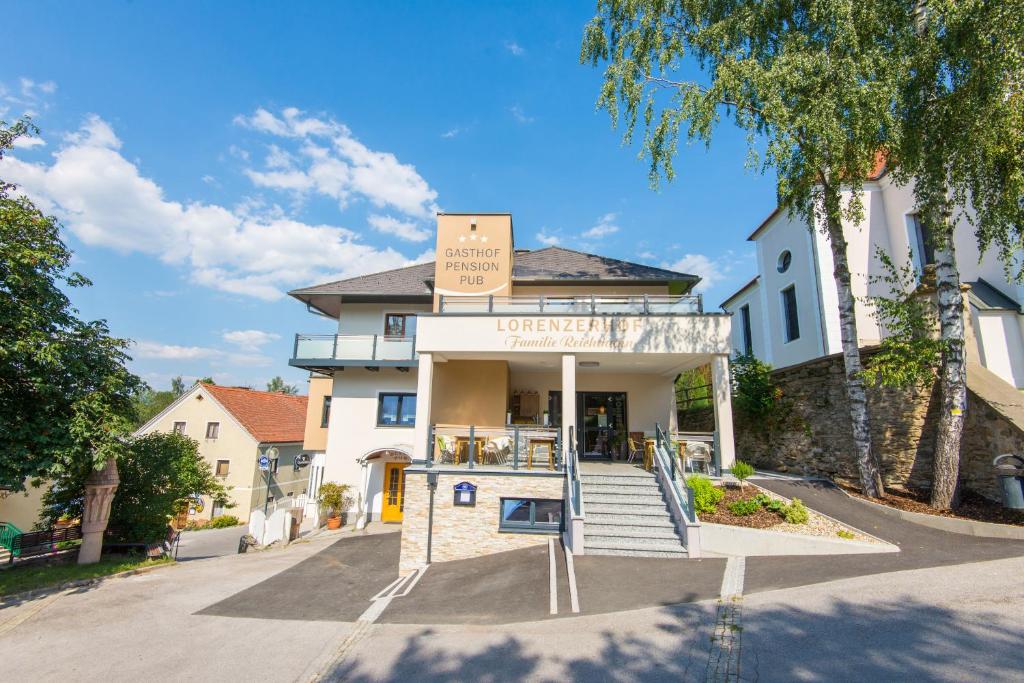 ein weißes Gebäude mit einem Schild darüber in der Unterkunft Lorenzerhof in Sankt Lorenzen am Wechsel