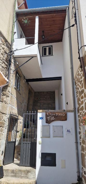 a white building with a door with a sign on it at Casa D'Avó Tiz in Avô