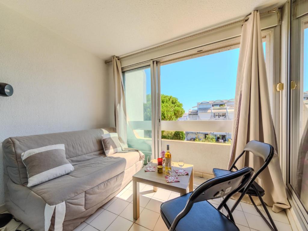 un salon avec un canapé et une table dans l'établissement Apartment Les Floralies II-14 by Interhome, au Grau-du-Roi