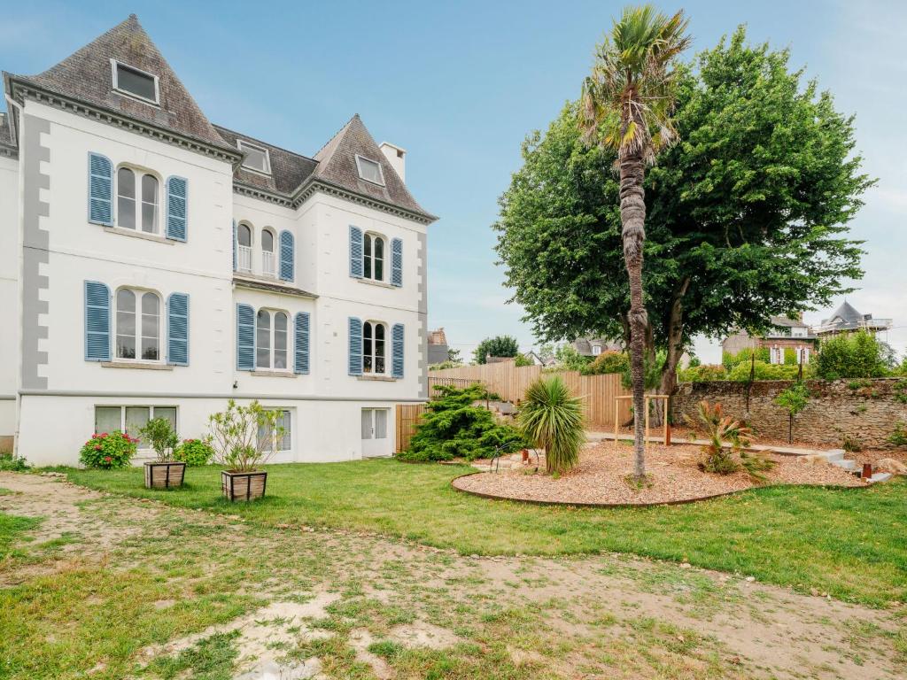 una gran casa blanca con una palmera en el patio en Villa Blanc Castel by Interhome, en Saint-Briac-sur-Mer