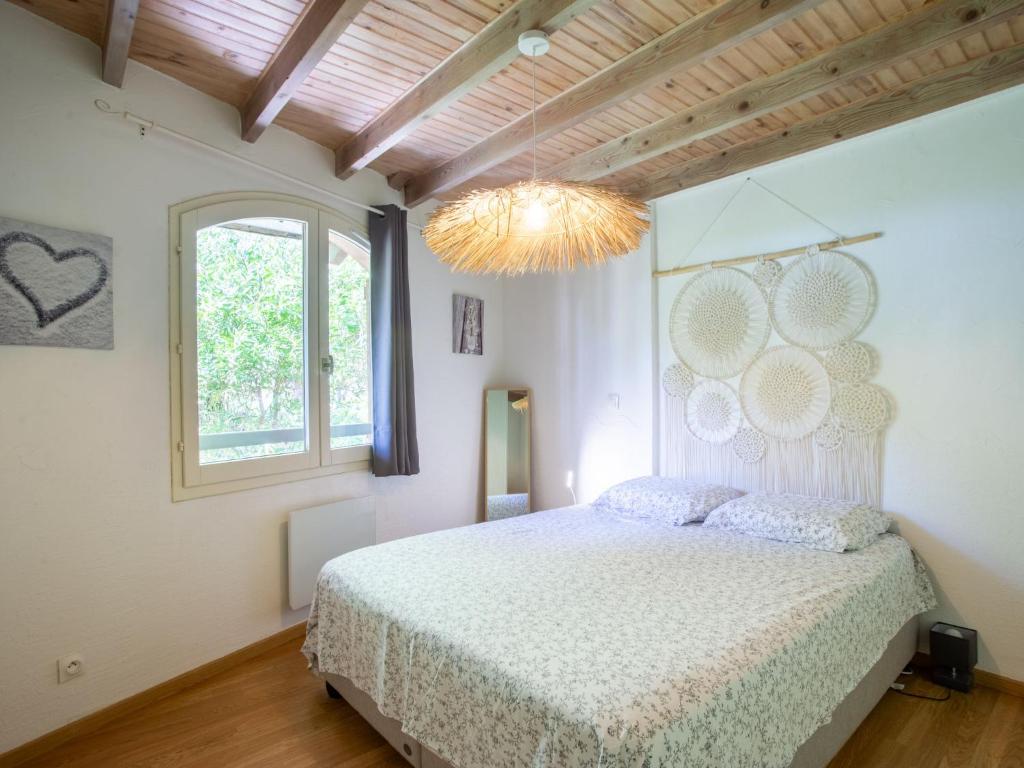 une chambre avec un lit, une fenêtre et un lustre dans l'établissement Holiday Home Jean d'Agreve-1 by Interhome, à Hyères