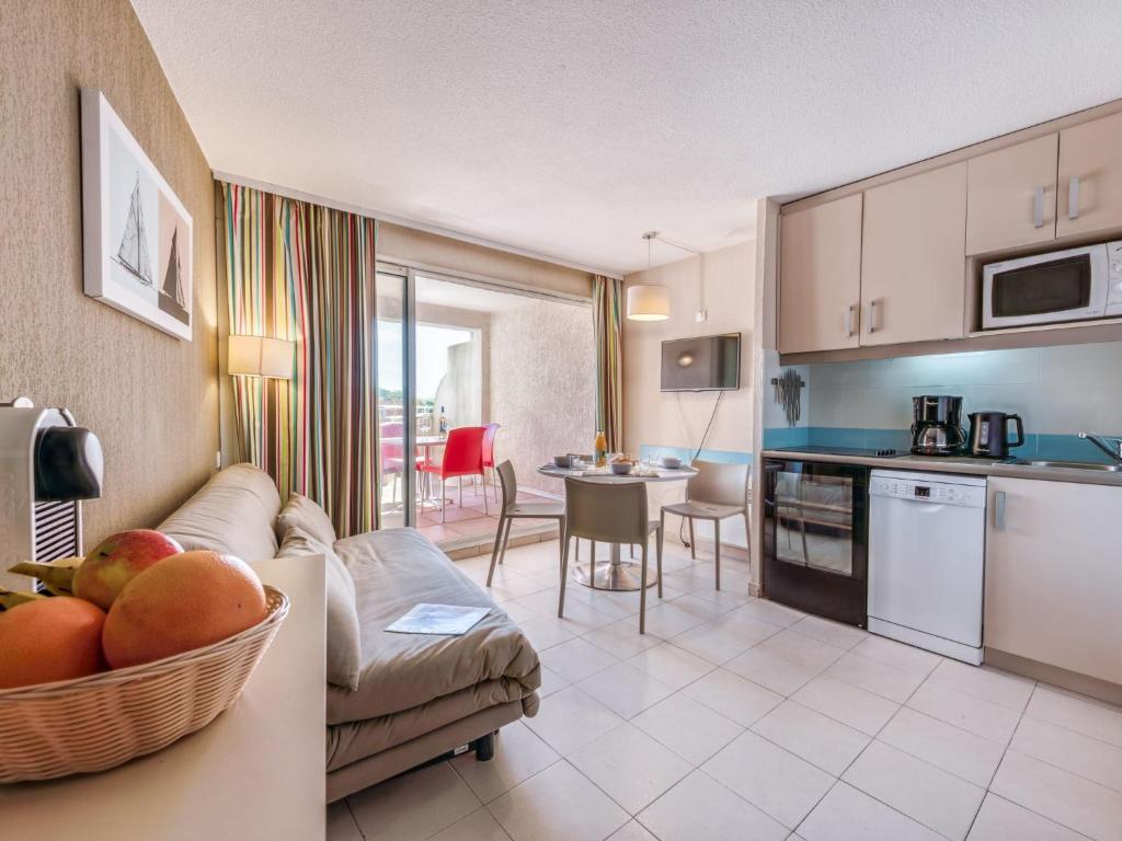 une cuisine et un salon avec un canapé et une table dans l'établissement Apartment Les Marines-12 by Interhome, à Gassin
