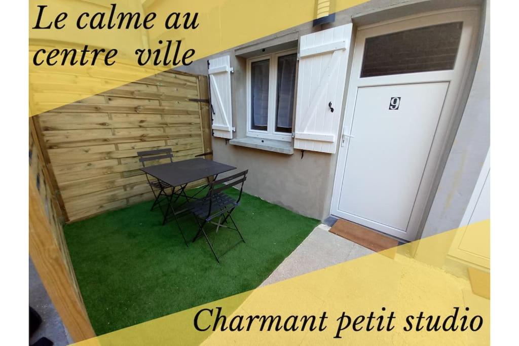 d'une petite terrasse avec une table et une porte blanche. dans l'établissement Residence de l'évèché 9, à Limoges