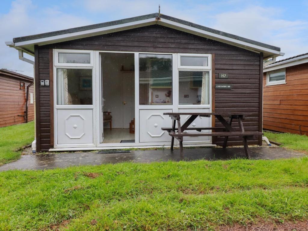 a small shed with a picnic table in front of it at Constantine Bay in Padstow