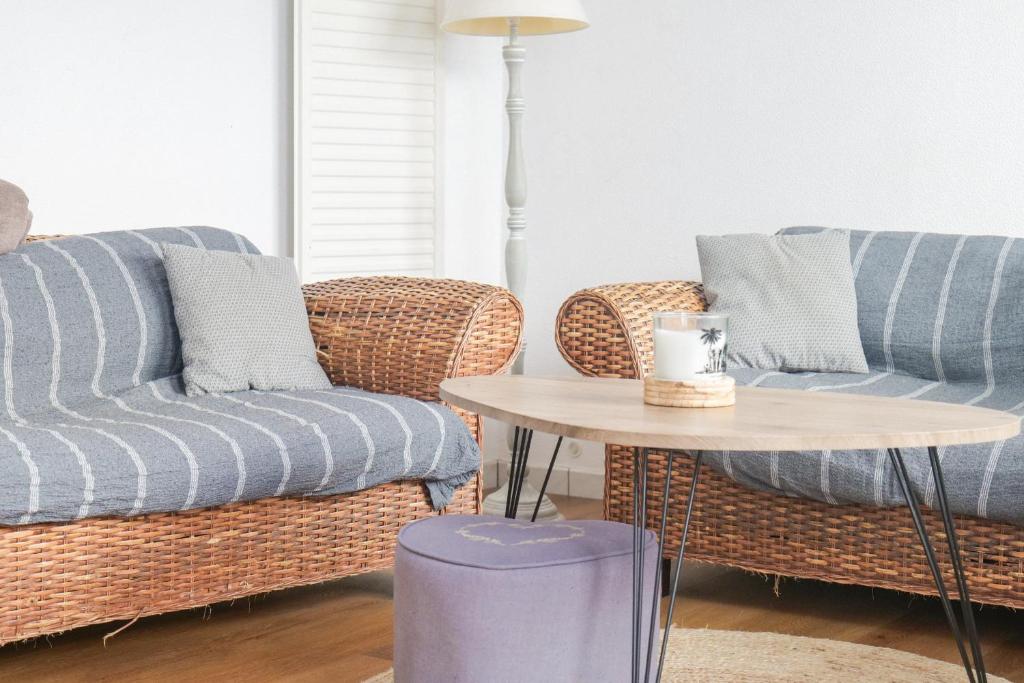 a living room with two couches and a table at Maison mitoyenne cœur de ville à deux pas du port de pêche et de la plage Les Sables - 6 personnes in Les Sables-dʼOlonne