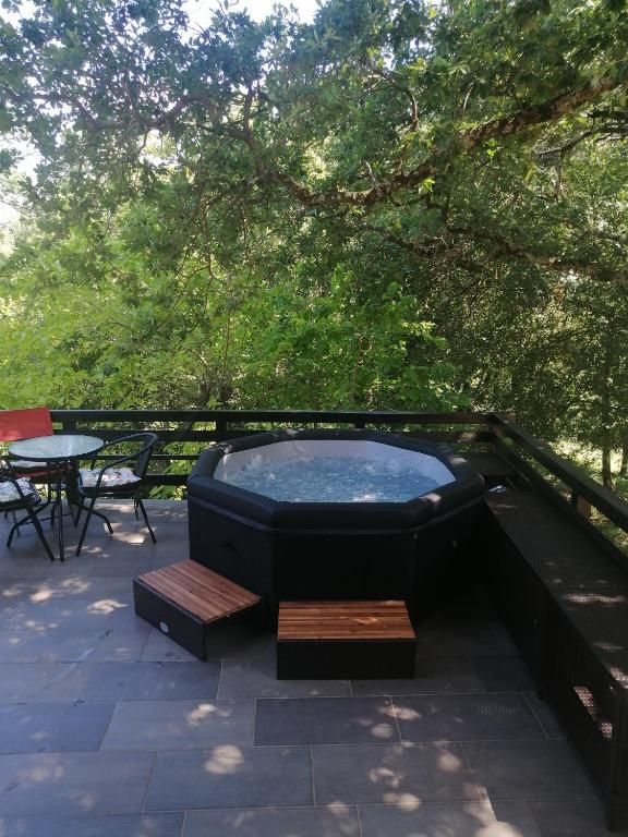 - un bain à remous sur une terrasse avec une table et des chaises dans l'établissement Gîte des oliviers, à Saint-Christol-de-Rodières