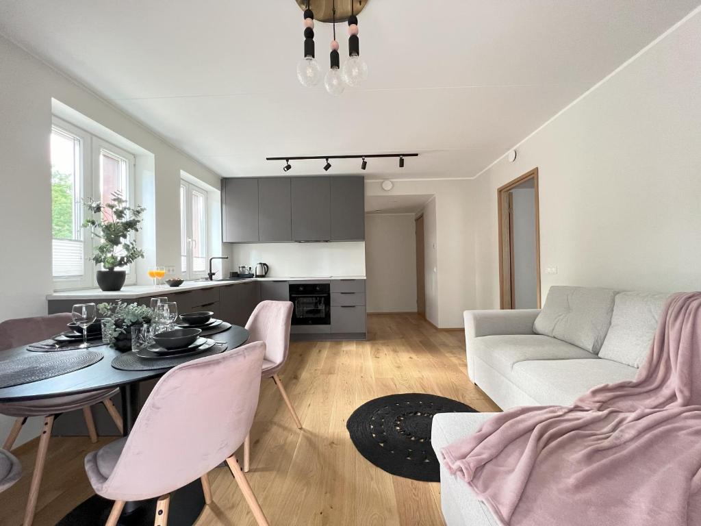 una sala de estar con una mesa y un sofá en Cozy Tartu Apple Garden with Terrace, en Tartu