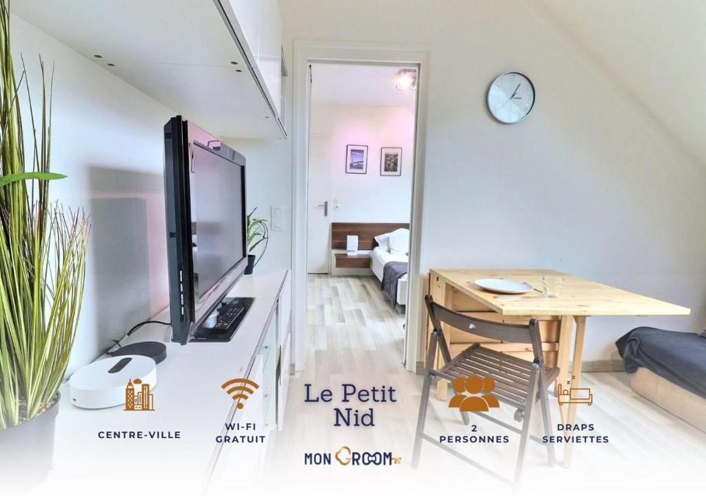 Elle comprend un salon avec une télévision et un bureau avec un ordinateur. dans l'établissement Le P'tit Nid - Cosy et Lumineux - Mon Groom, à Troyes