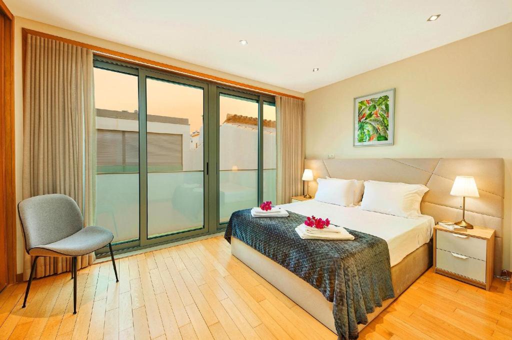 una habitación de hotel con una cama y una silla en Beautiful Town Centre Townhouse With Shared Pool, en Tavira