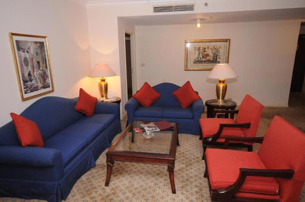 a living room with a blue couch and red chairs at Cairo house in Cairo