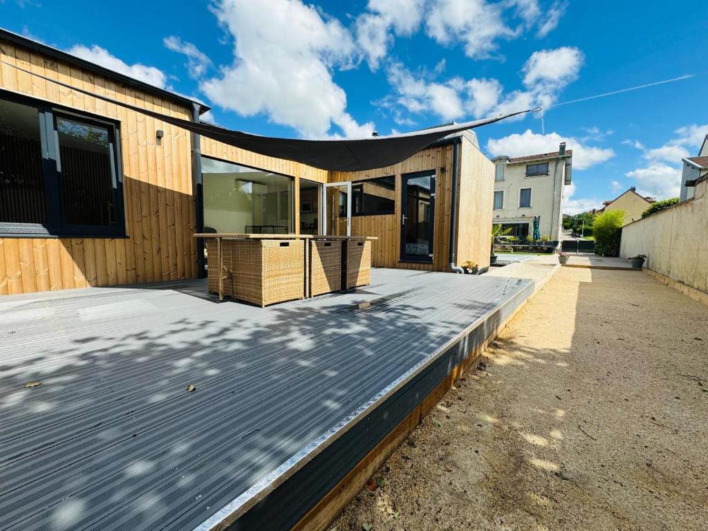 a wooden deck with a roof on a house at Chalet moderne animaux acceptés in Vittel