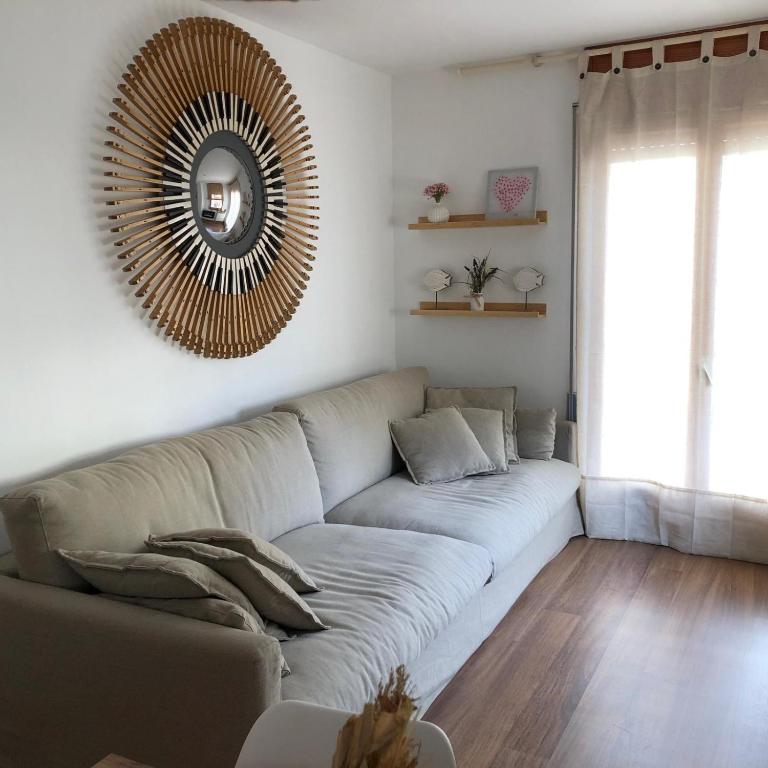 a living room with a couch and a mirror at Quatrecantons Camprodon in Camprodon