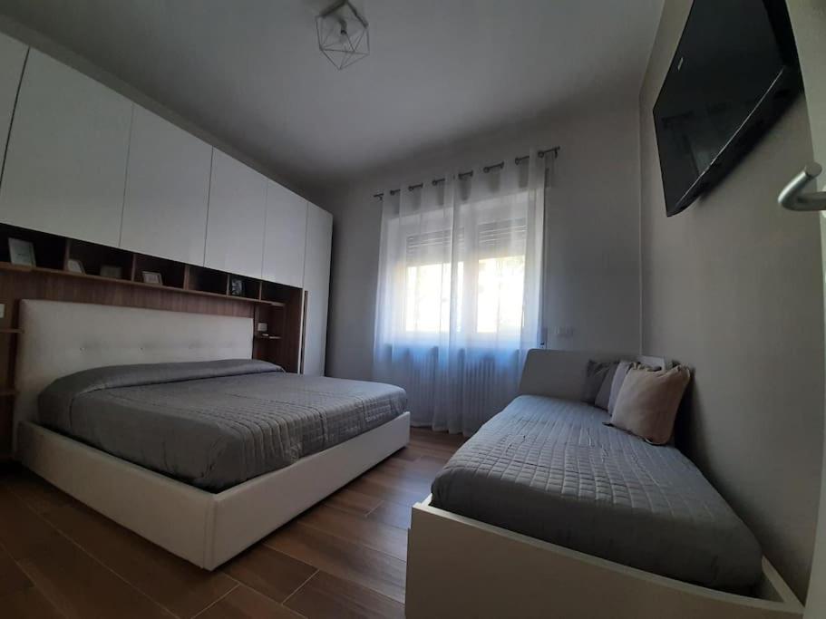 a bedroom with two beds and a window at Arona Lovely House in Arona