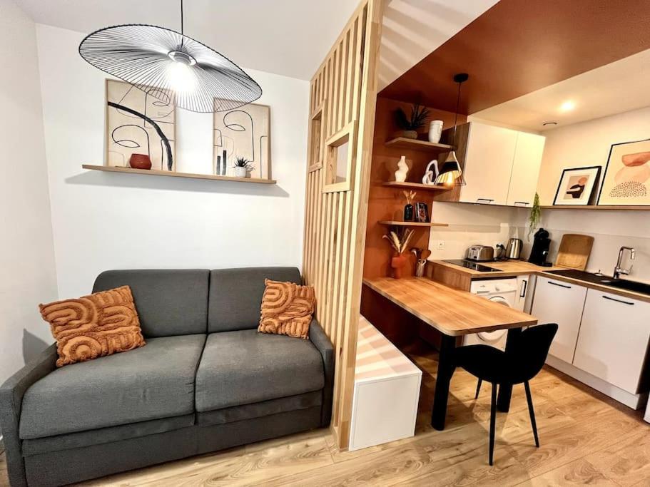 un salon avec un canapé et une table dans une cuisine dans l'établissement Zola 2pers Tv, à Nantes