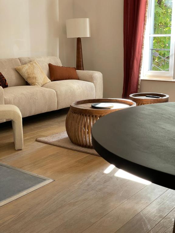 una sala de estar con un sofá y una mesa en MC Suite Briand CMZ Place-Ducale, en Charleville-Mézières