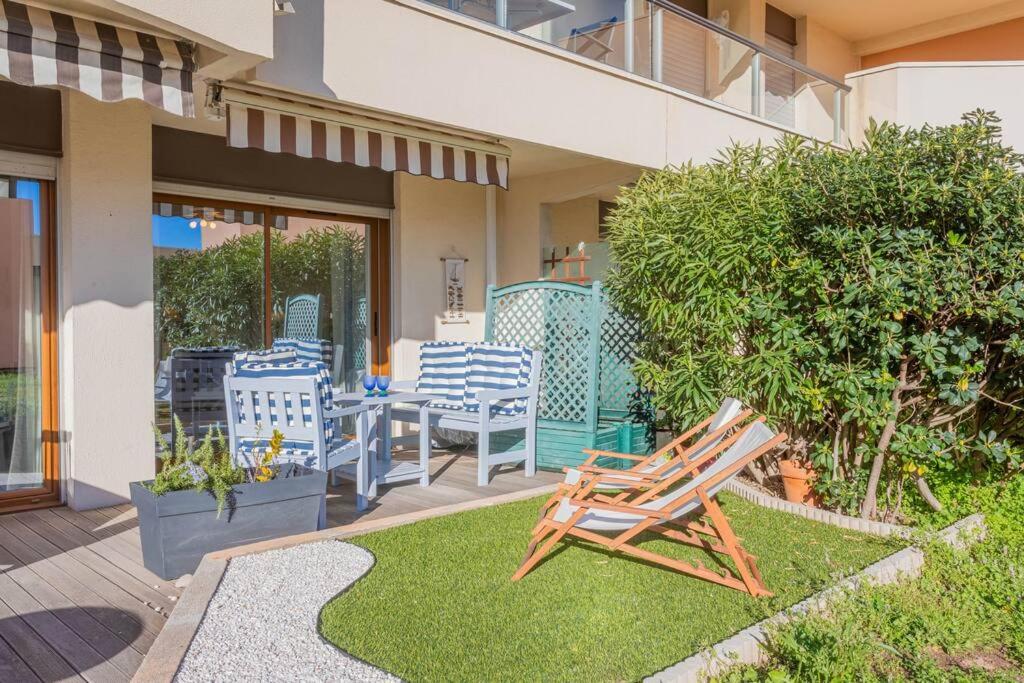 d'une terrasse avec des chaises et une table dans la cour. dans l'établissement Appt vue Mer 5 min centre et plage, à Saint-Raphaël