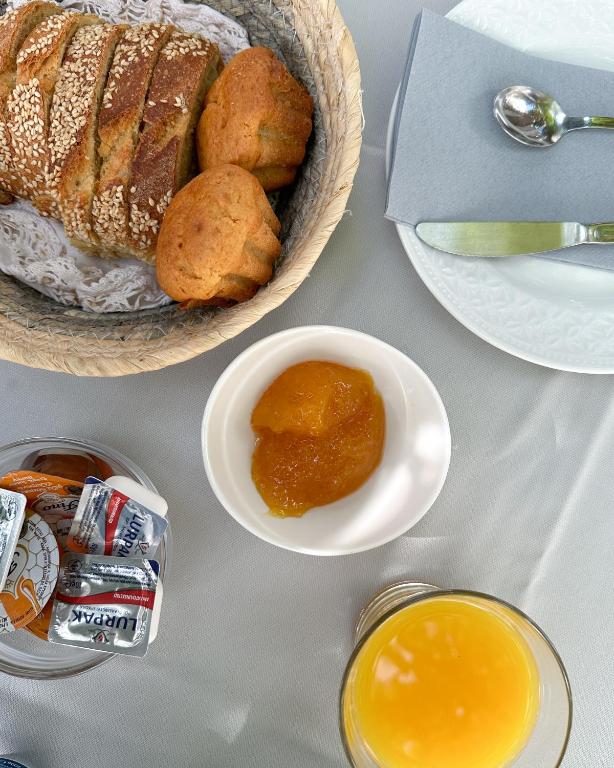 a table with a basket of bread and a bowl of honey at Hotel Miranda in Hydra