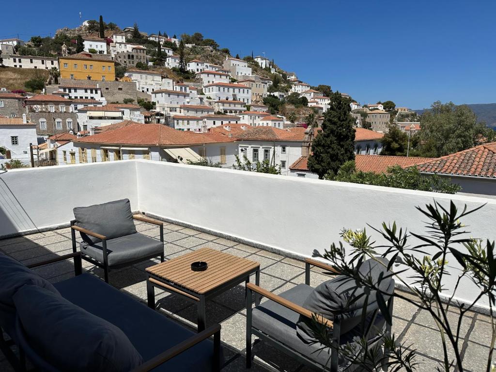 a patio with chairs and a table on a balcony at Hotel Miranda in Hydra