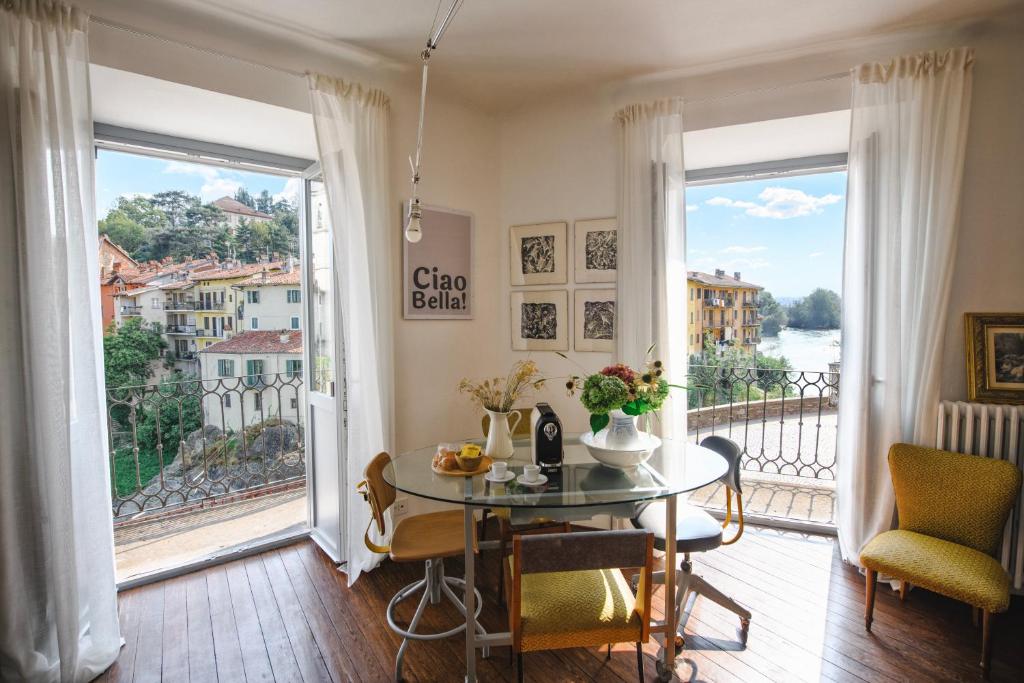 a dining room with a table and a large window at Archè in Ivrea