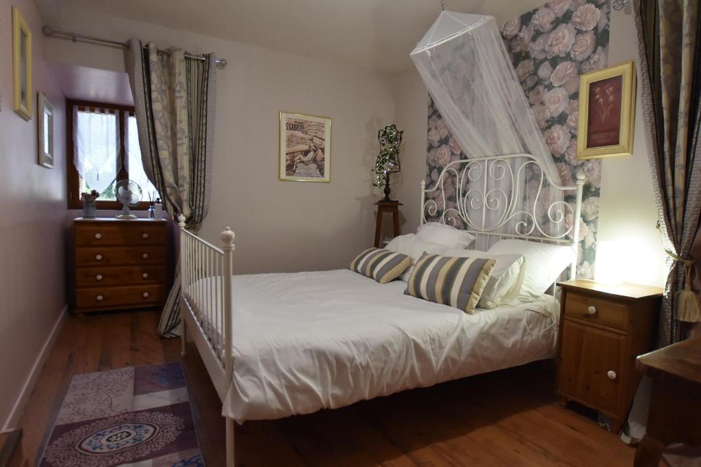 a bedroom with a white bed with a canopy at Les Girouteaux La bergerie in Les Eyzies-de-Tayac