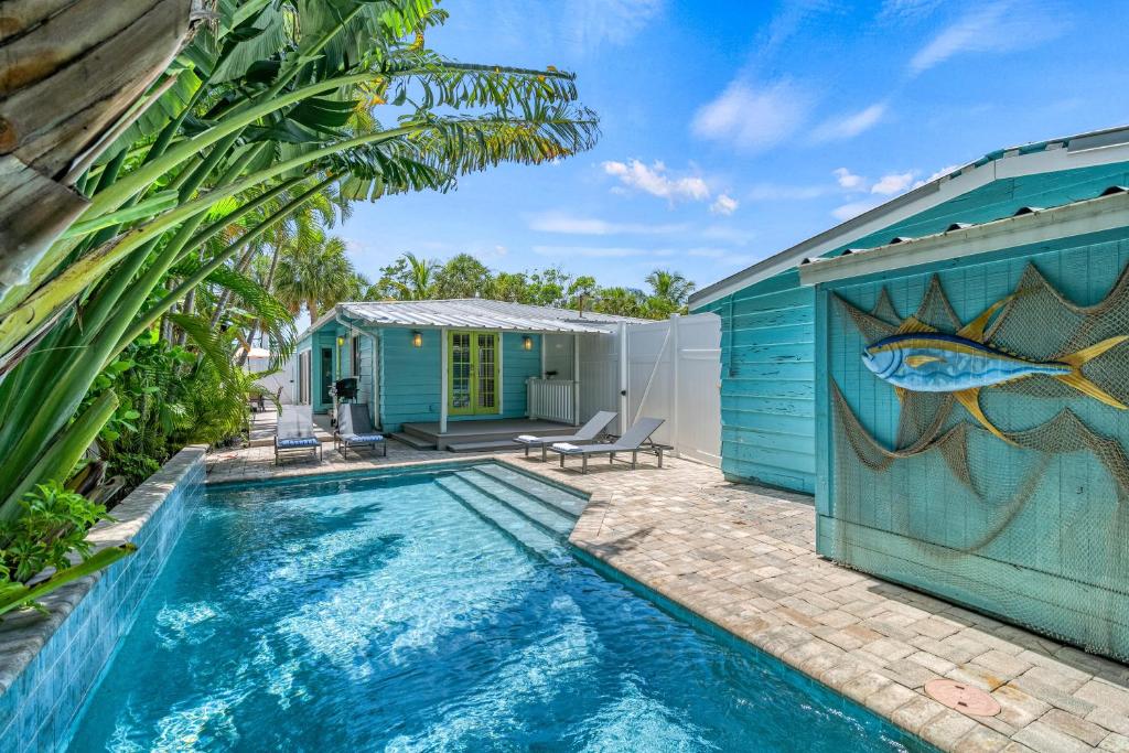 a house with a swimming pool next to a blue building at Toes in the Sand - 113 in Sarasota