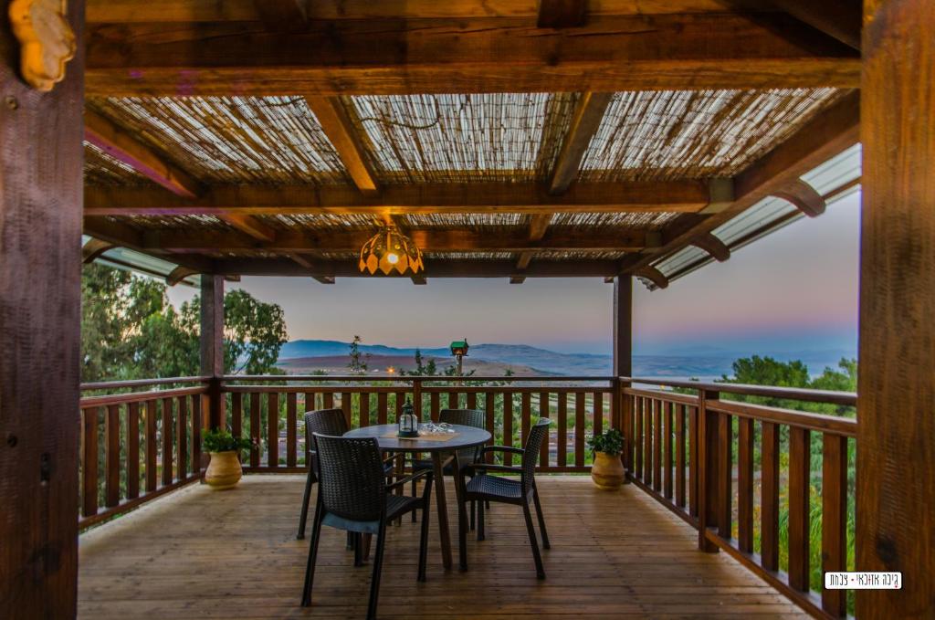 a patio with a table and chairs on a deck at Beautiful Lake View Wooden House in Tiberias