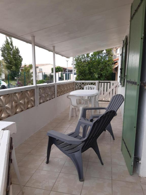 un patio avec deux chaises et une table sur un balcon dans l'établissement Maisonnette de plain pied, au Barcarès