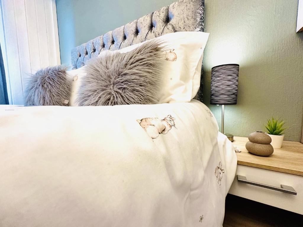 a bedroom with a bed with pillows on it at Warren Cottage in Bridlington