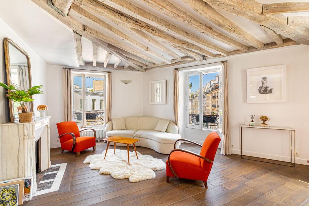 un salon avec un canapé et des chaises dans l'établissement GuestReady - Séjour confortable dans le 9ème, à Paris