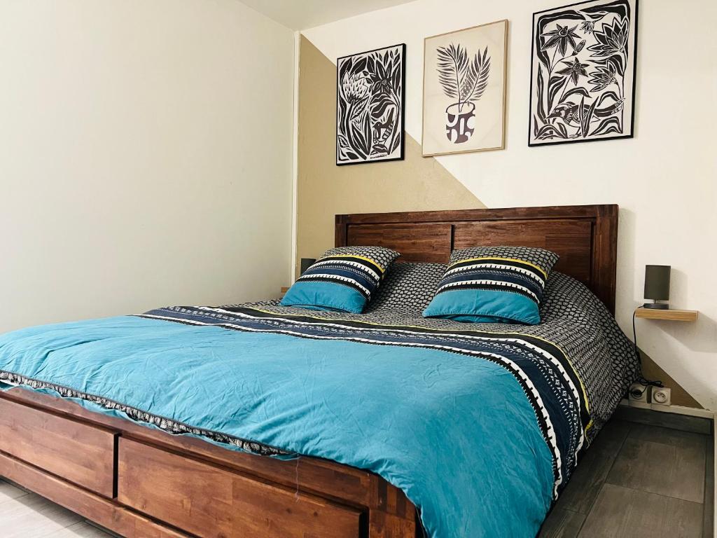 - une chambre avec un lit en bois et 2 oreillers bleus dans l'établissement Studio Leskal centre Cilaos, à Cilaos