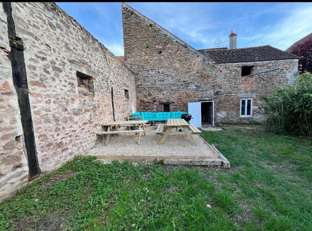 a picnic table in front of a stone building at "L'escargot" Maison familiale - Les Terres du Roy in Avallon