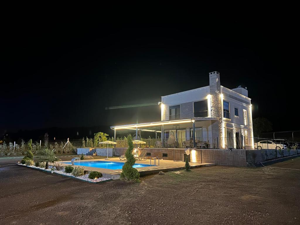 a large white house with a swimming pool at night at GREEN VALLEY House in Avanos