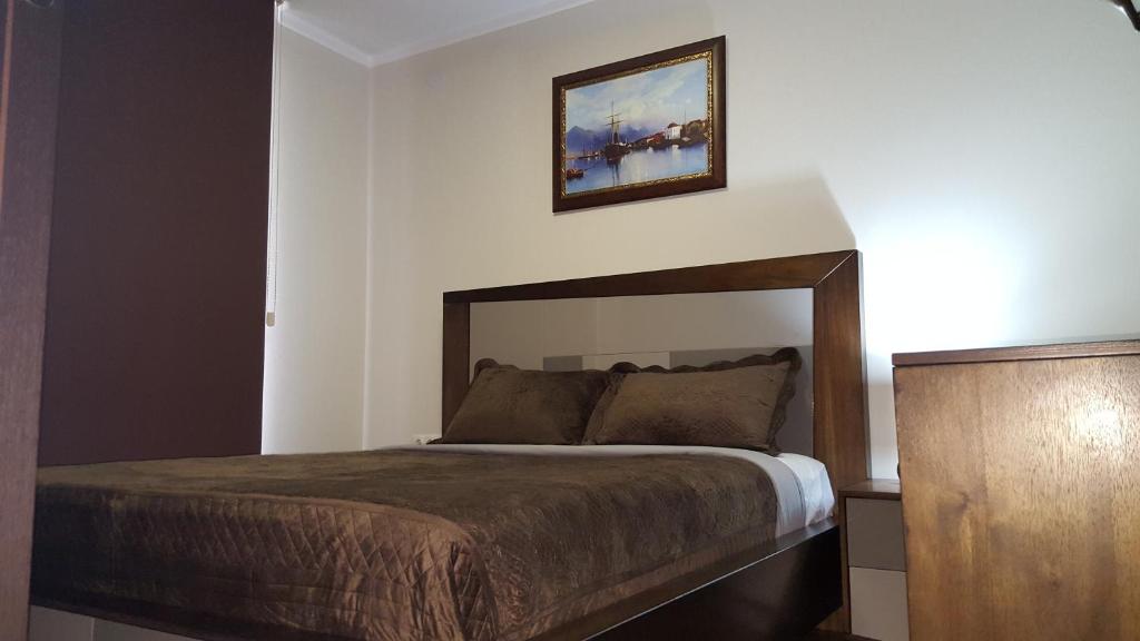 um quarto com uma cama e uma fotografia na parede em Mimino Apartment Deluxe First Line (K III) em Batumi