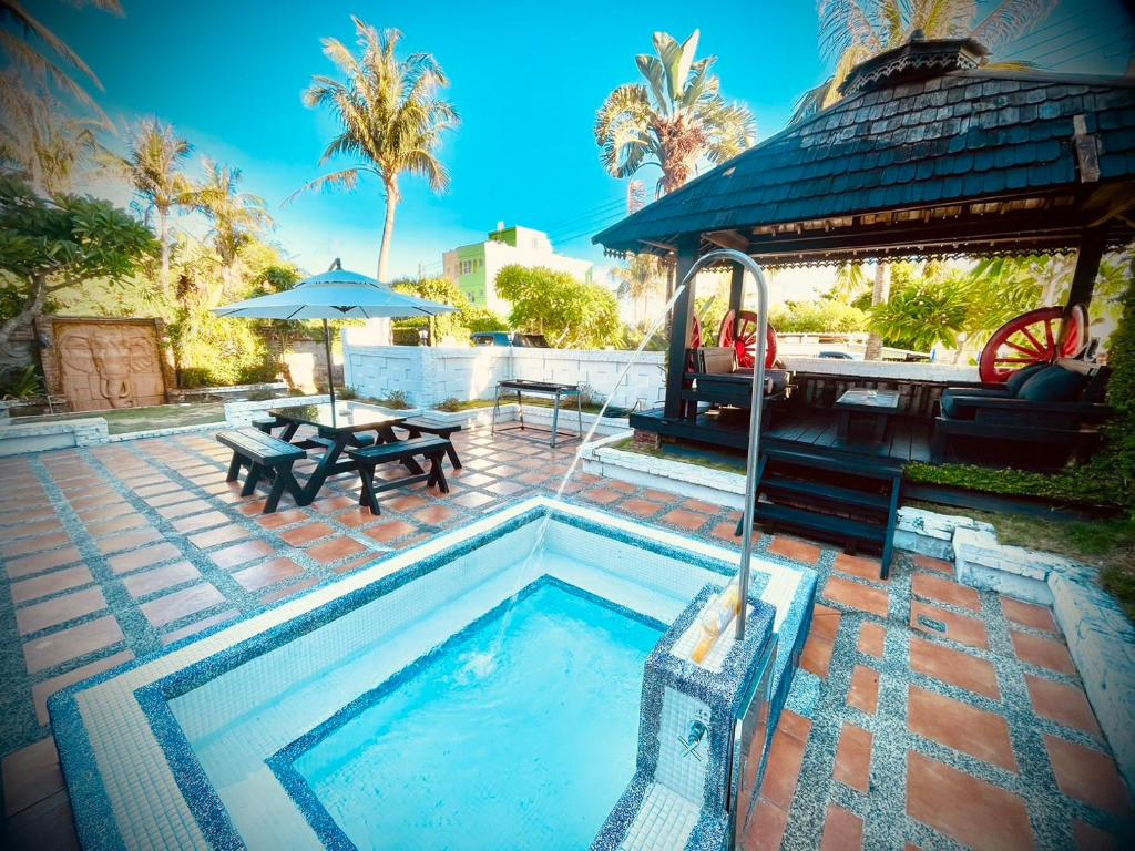 una piscina con tavolo e tavolo da picnic di Ubud Villa a Città Vecchia di Hengchun