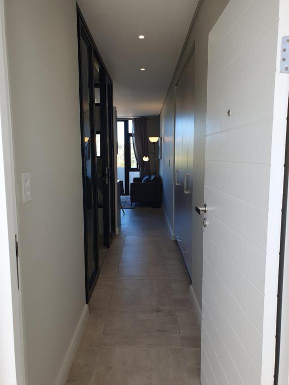 a hallway with a hallway leading to a room with a door at The Paramount and The Supreme at Bellamare in Summerstrand