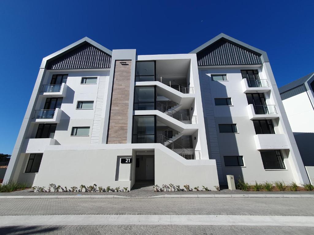 a large white apartment building with two roofs at The Paramount and The Supreme at Bellamare in Summerstrand