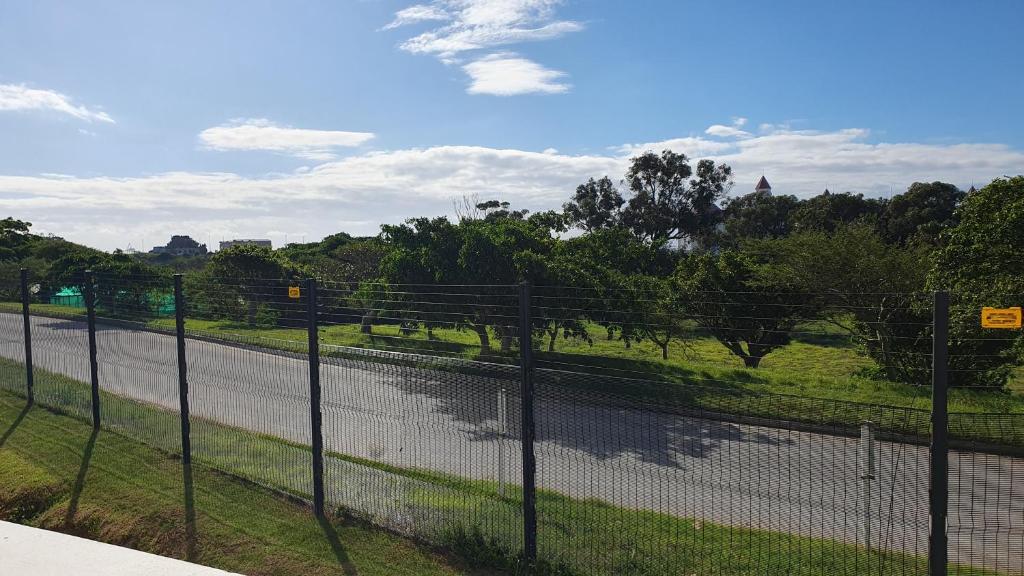 a fence on the side of a road next to a field at The Paramount and The Supreme at Bellamare in Summerstrand