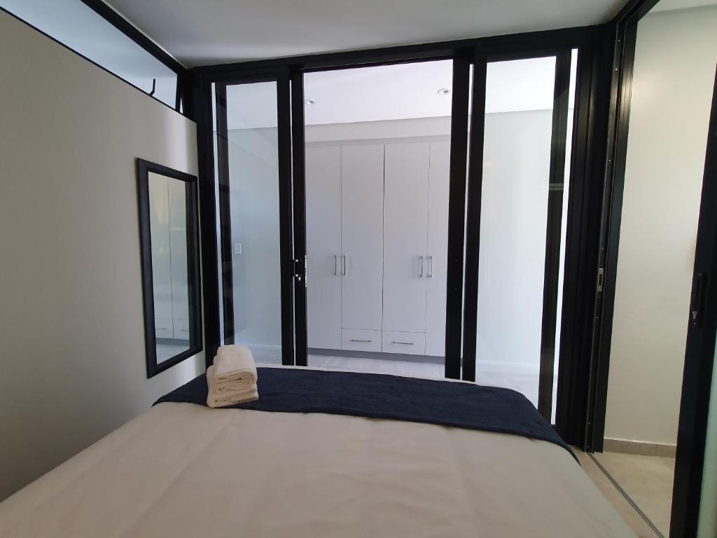 a bedroom with a bed and large glass windows at The Paramount and The Supreme at Bellamare in Summerstrand