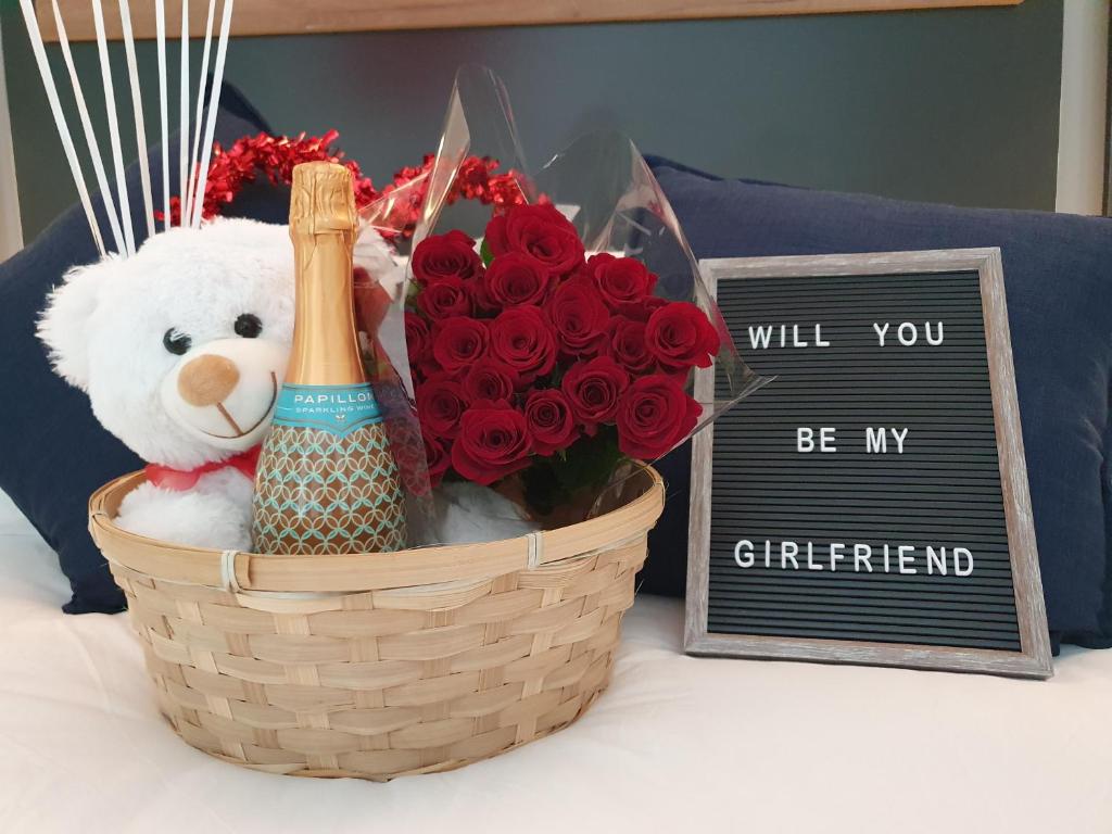 a basket of flowers and a sign that reads will you be my girlfriend at The Paramount and The Supreme at Bellamare in Summerstrand